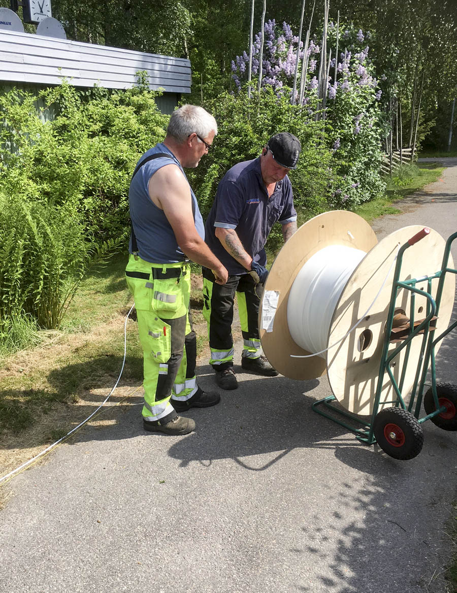 Fiberslangen rullas ut och grävs ner.