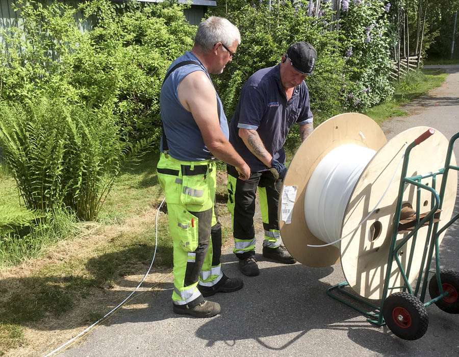 Fiberslangen rullas ut och grävs ner.